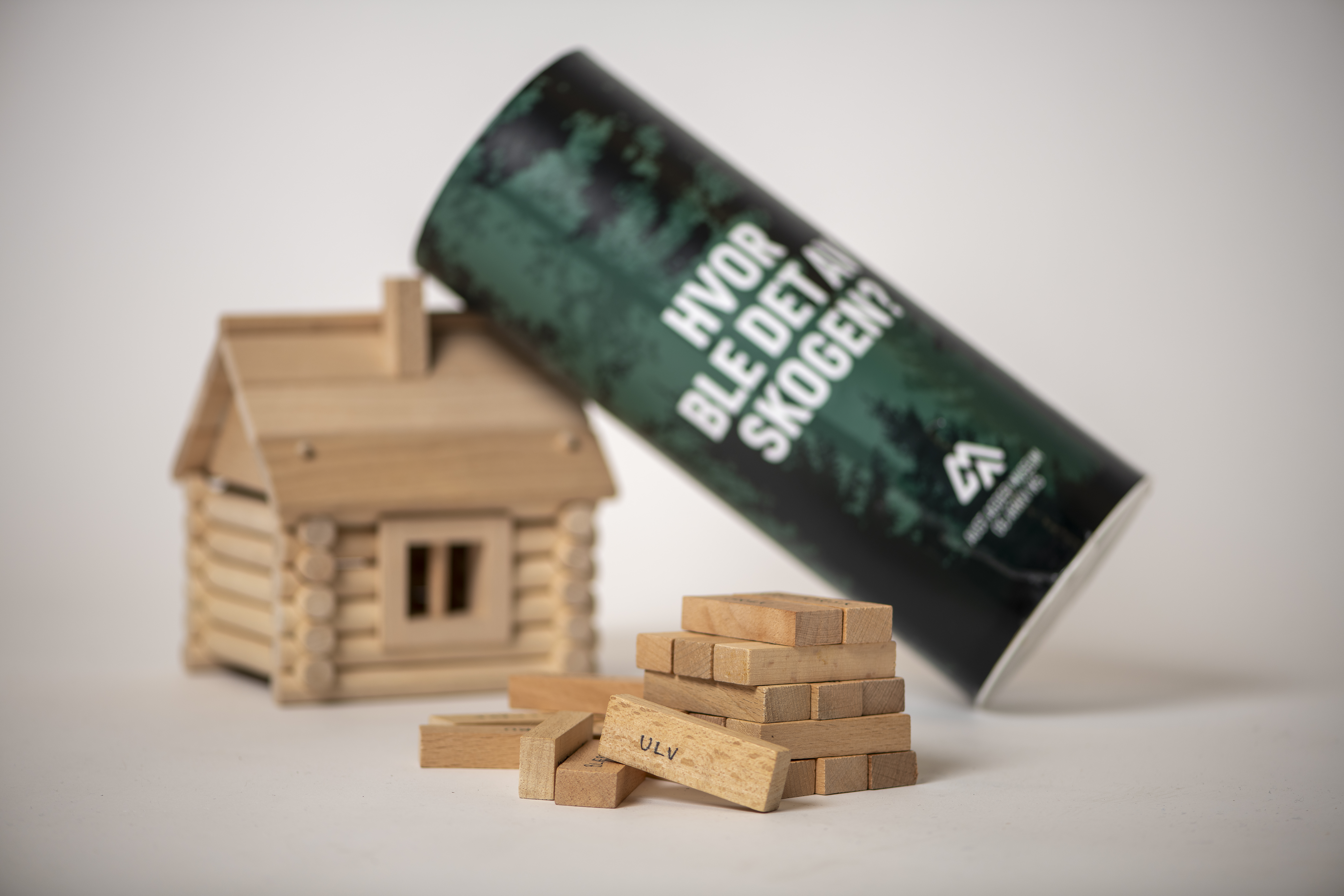 Modell av laftet tømmerhus og boks med Jenga-spill merket "Hvor ble det av skogen.